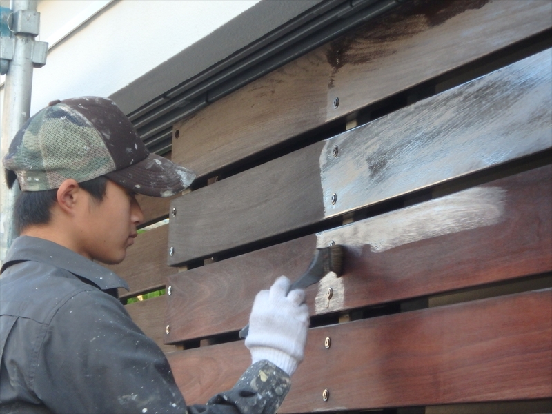 車庫の木製の扉を防腐剤入の塗料で塗装しています。