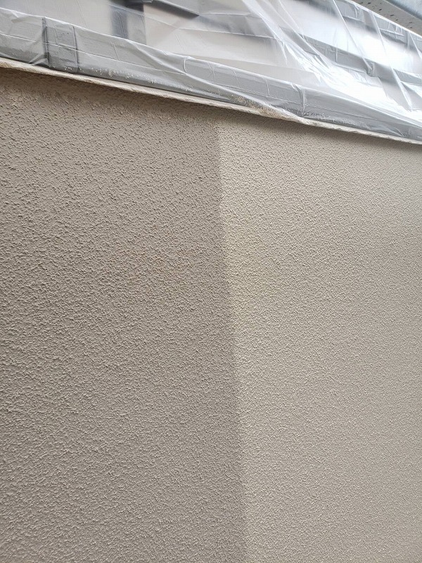 外壁の上塗りを行っています。汚れて困る場所はきちんと養生しています。