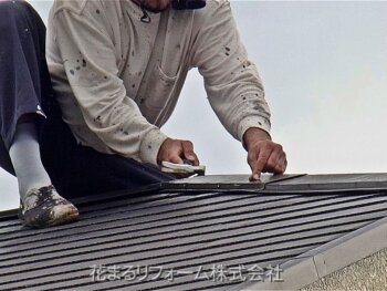 屋根に釘を打つ塗装職人