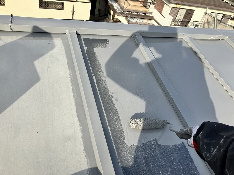 続いてローラーでトタン屋根の中塗りをしています。（エスケー化研 クールタイトSi CLR-106 グレー）