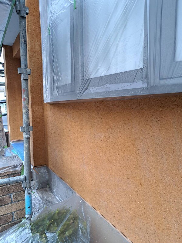 出窓や植栽がしっかり養生され、外壁の下塗り１回目が完了しました。（ヤブ原産業 ガッチリ浸透プライマーW）