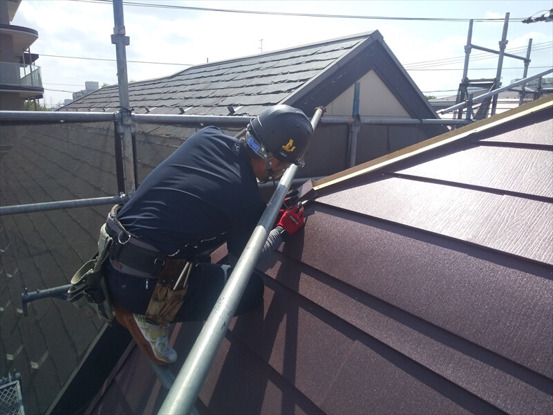 屋根を板金で覆った後、棟の部分を板金で覆っています。